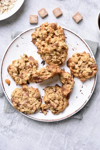 a plate of oatmeal cookies next to a bowl of oatme