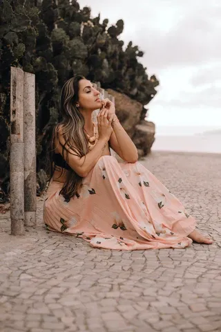 a woman sitting on the ground with a cell phone