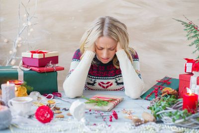 a woman sitting at a table covered in presents