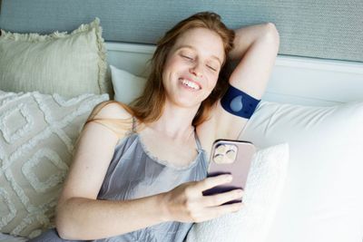 a woman laying on a bed holding a cell phone