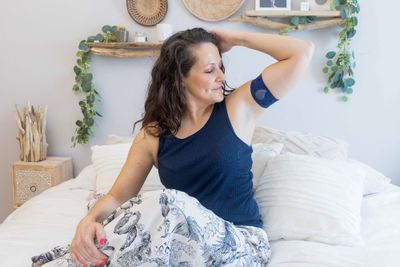 a woman sitting on top of a bed in a bedroom