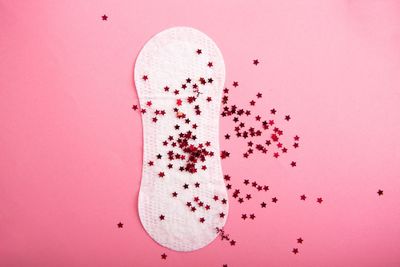 a pair of white socks with red stars on a pink background