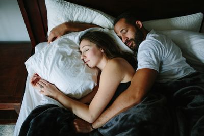A man and a woman laying in bed together.