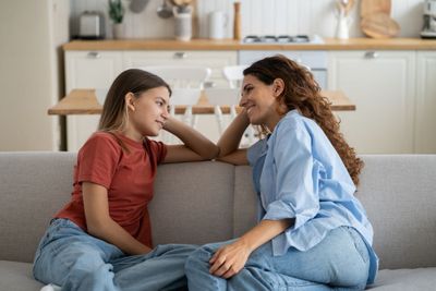 two women sitting on a couch talking to each other