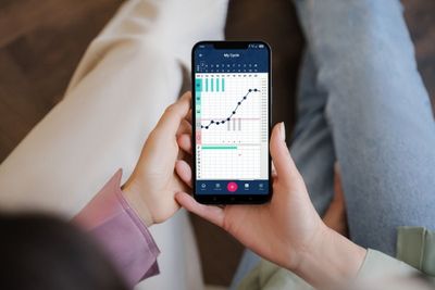 a person holding a cell phone with a chart on the screen