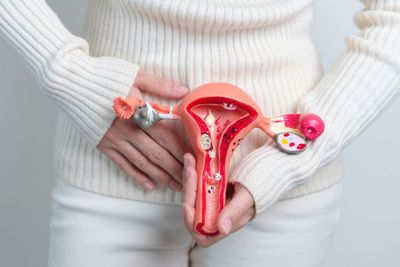 a woman is holding a fake utensil in her stomach