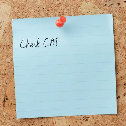 a note pinned to a cork board that says check cm