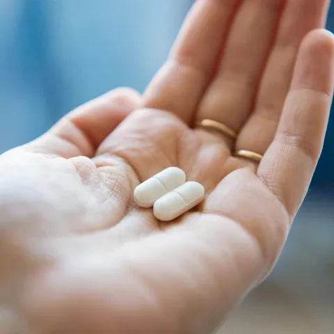 a person holding a pill in their hand