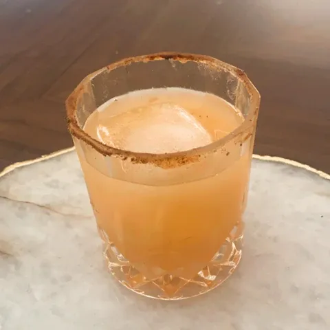 a glass filled with a drink sitting on top of a table