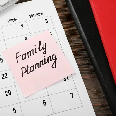 a pink sticky paper pinned to a calendar with the words family planning on it