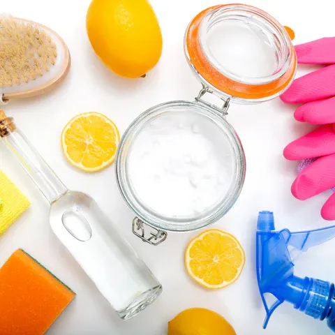 a white table topped with oranges and cleaning supplies