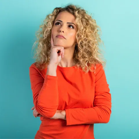 a woman in an orange shirt is posing for a picture