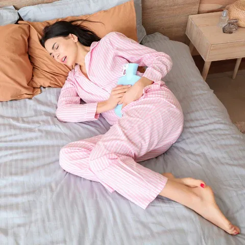 a woman in pink pajamas laying on a bed