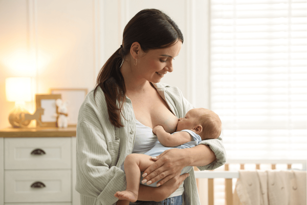 a woman breastfeeding her baby in the nursery