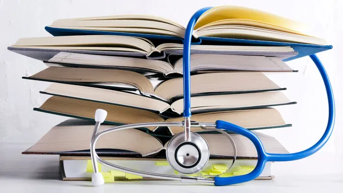 a stack of books with a stethoscope on top of it