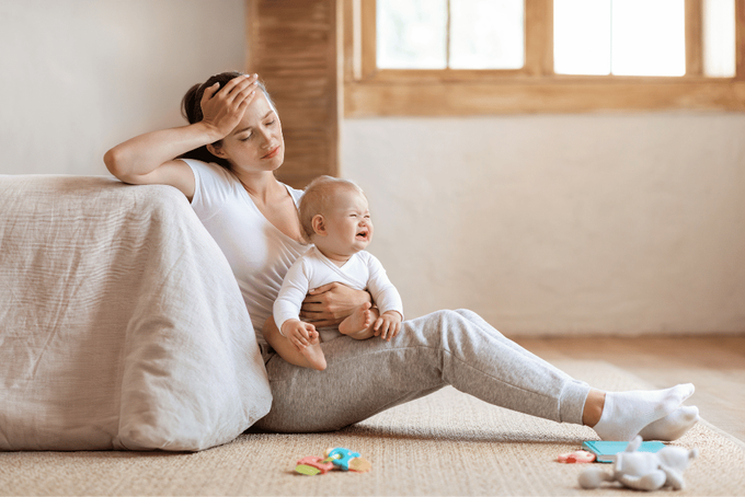 A tired mother and her 4-month-old baby experiencing the typical developmental milestones and sleep regressions
