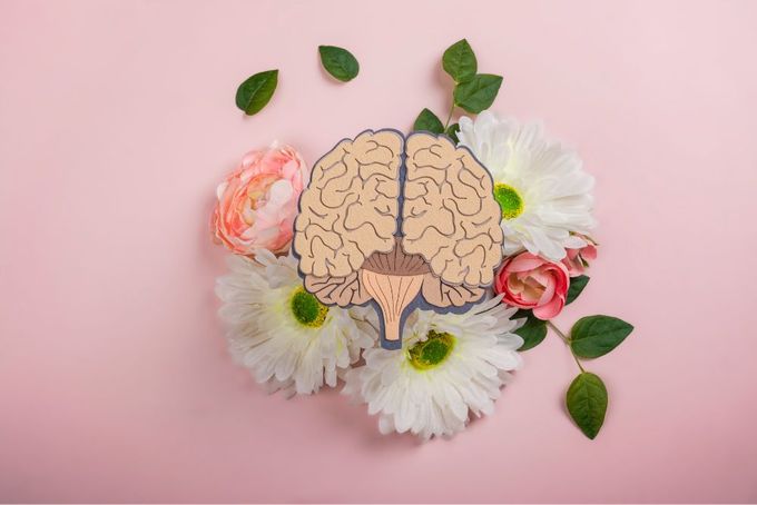 a paper cutout of a human brain surrounded by flowers
