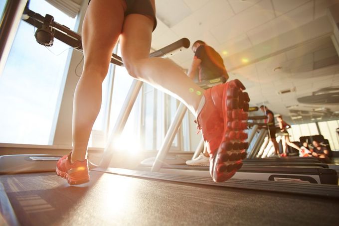 a woman running on a treadmill in a gym