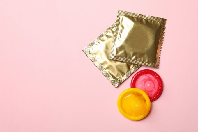 a condom and a condom bag on a pink background