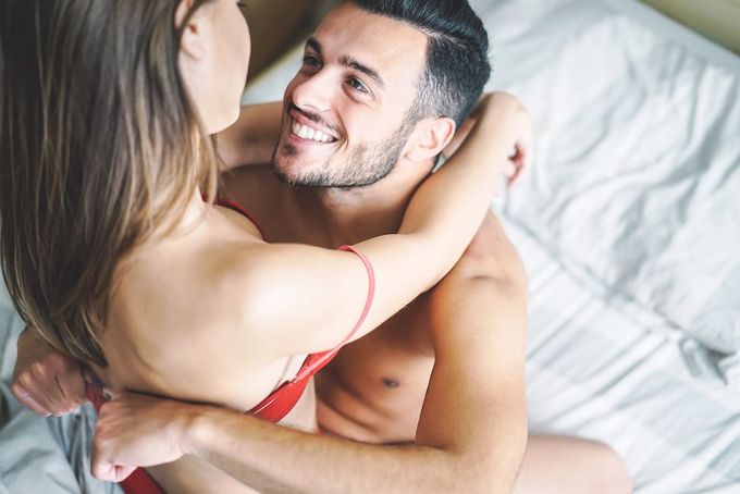 a man and a woman laying on top of a bed