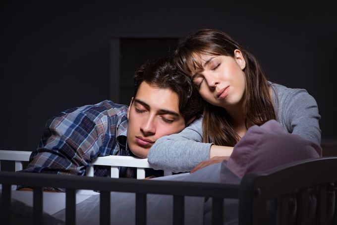 a man and a woman laying in a crib