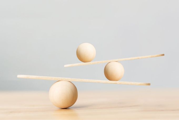three wooden balls balancing on a wooden stick