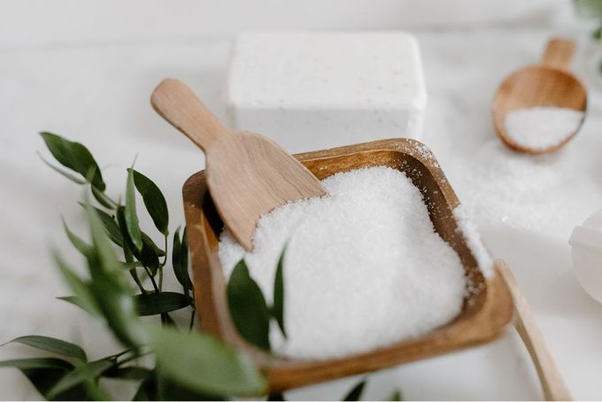 a bowl of sugar and a wooden spoon