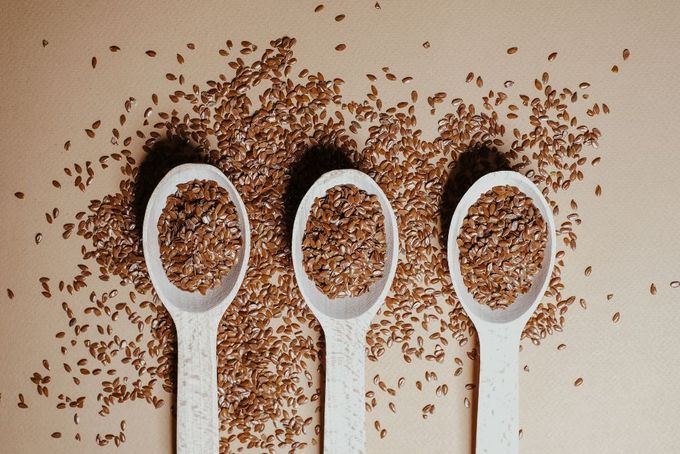 three spoons filled with seeds on top of a table
