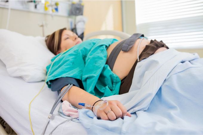 a woman laying in a hospital bed with an oxygen tube
