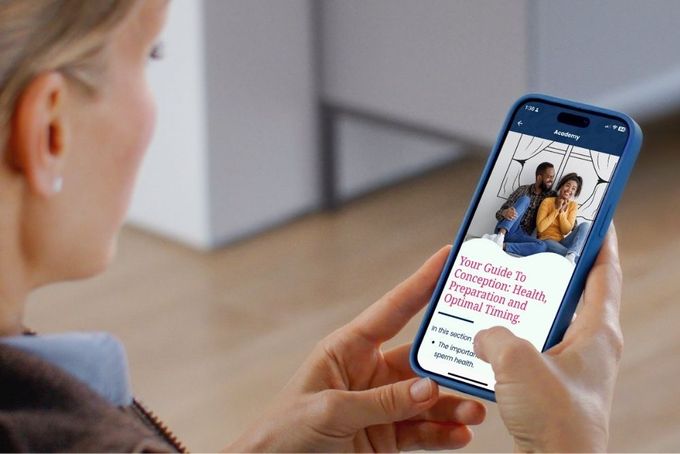Tempdrop Academy a woman holding a cell phone with a picture on the screen