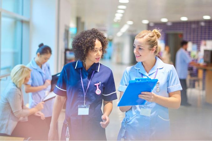 two women in scrubs talking to each other