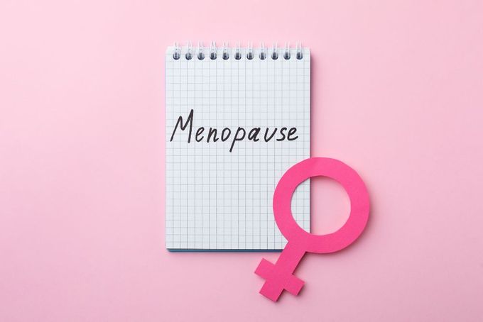 a notepad with the word menopase written on it next to a pink