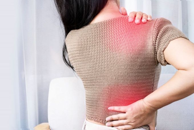 a woman holding her back in pain
