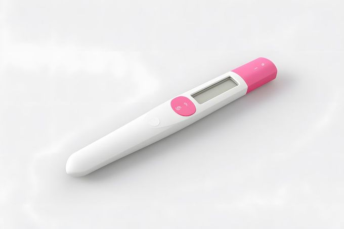 OPK a pink and white digital thermometer on a white surface