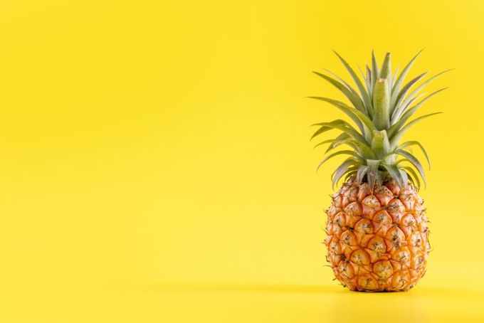 a pineapple on a bright yellow background