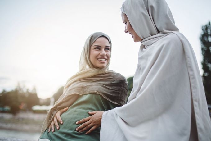 a woman in a shawl is hugging another woman