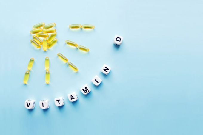 vitamins and pills arranged in the shape of a sun on a blue background