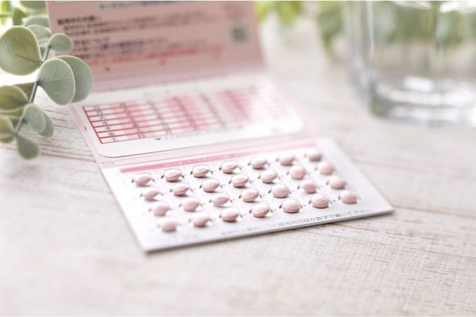 a close up of a pill pack and a glass of water