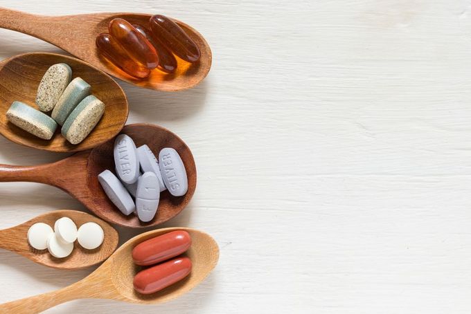 prenatal vitamins three wooden spoons filled with different types of pills