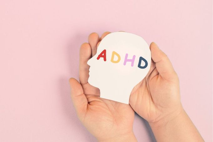 a person holding a piece of paper with the word adhd on it