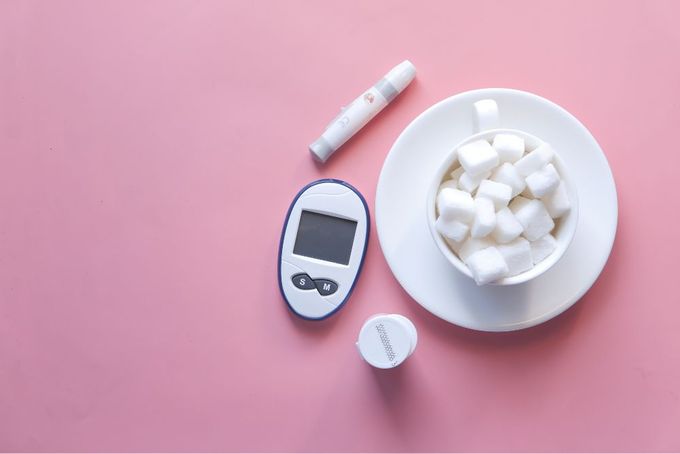 a bowl of marshmallows and a thermometer on a pink surface