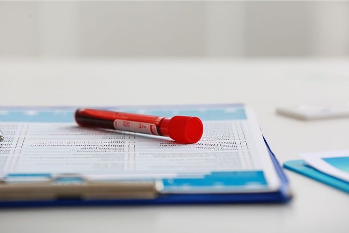 a red pen sitting on top of a piece of paper