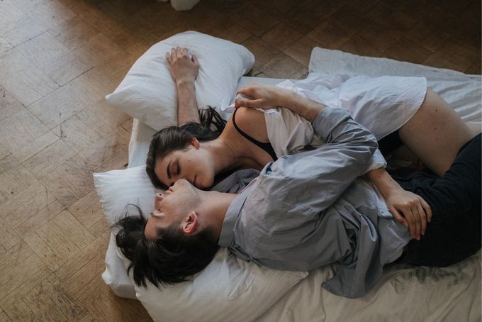 a man and woman laying on a bed together
