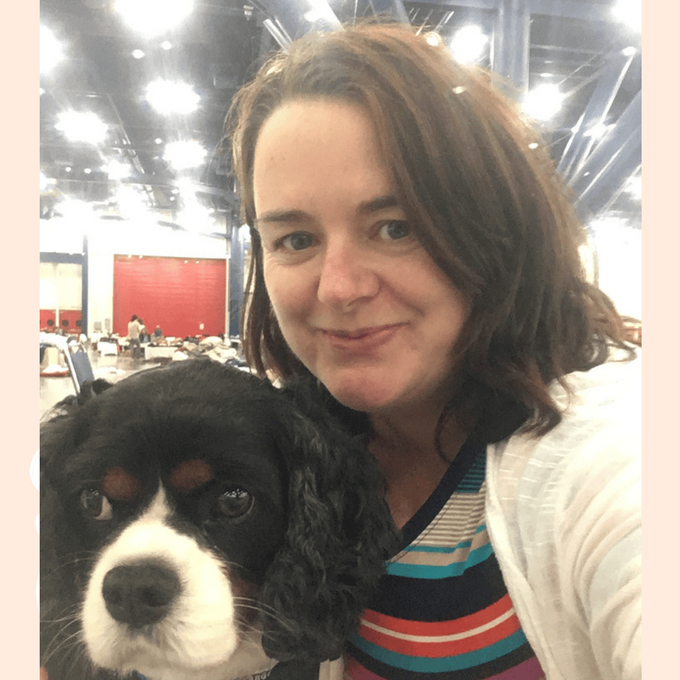 a woman holding a Cavalier King Charles Spaniel