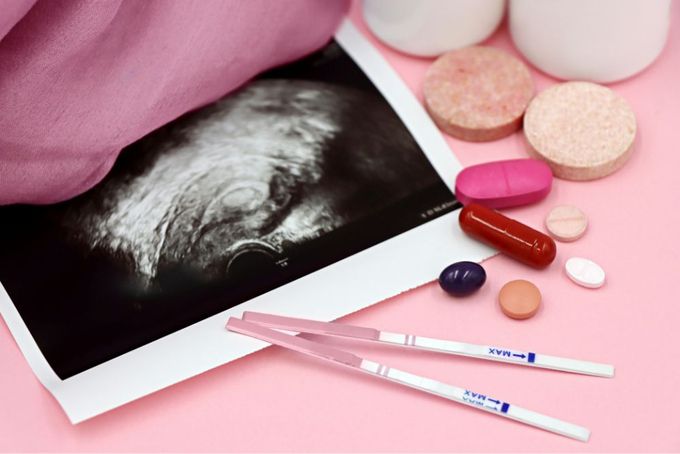 a pink table with pills, pills, and a picture of a person's