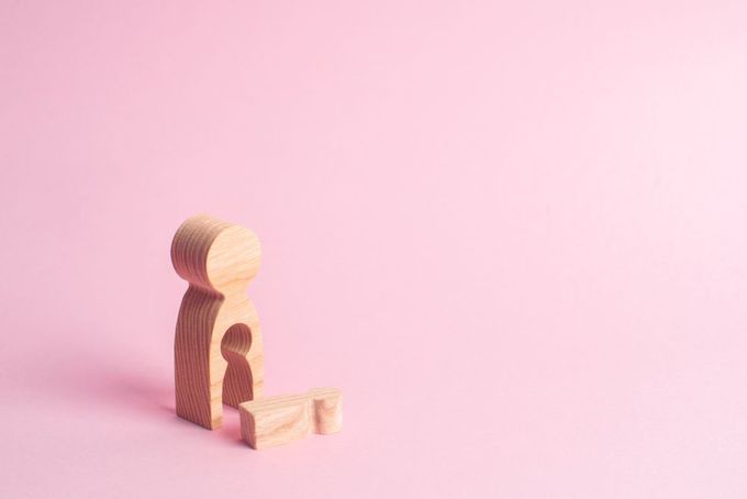 a wooden toy sitting on top of a pink surface