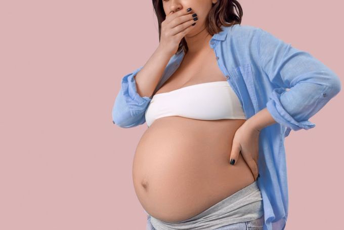 a pregnant woman in a white bikini posing for a picture