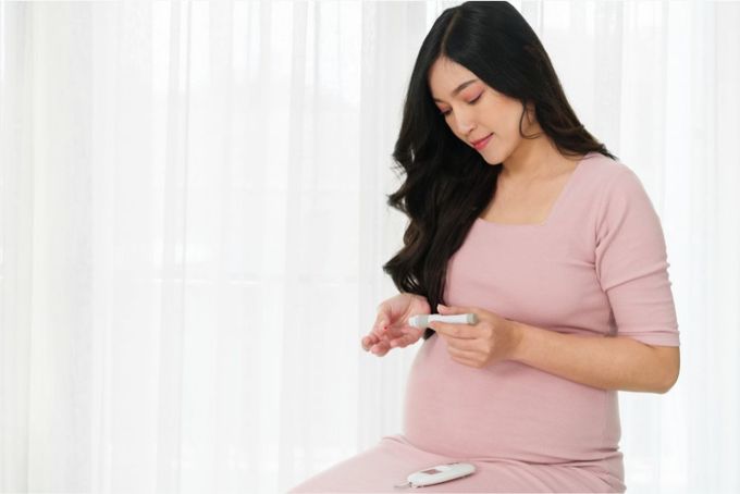 a pregnant woman holding a thermometer in her hand