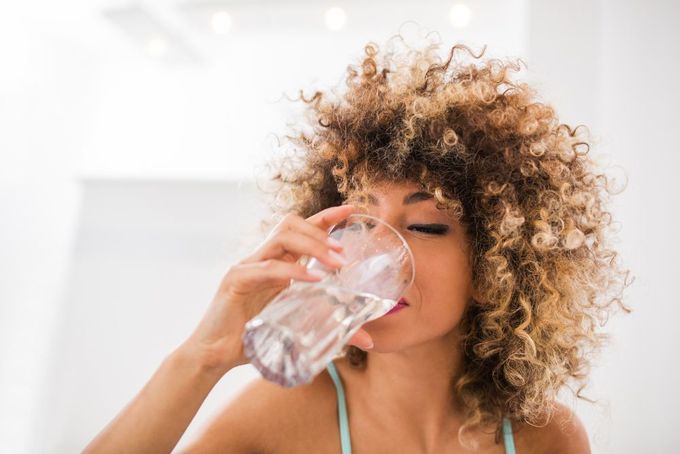a woman drinking a glass of water