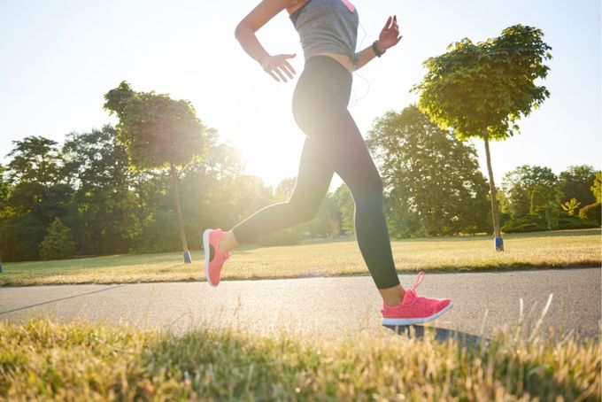 a woman running in a park on a sunny day
